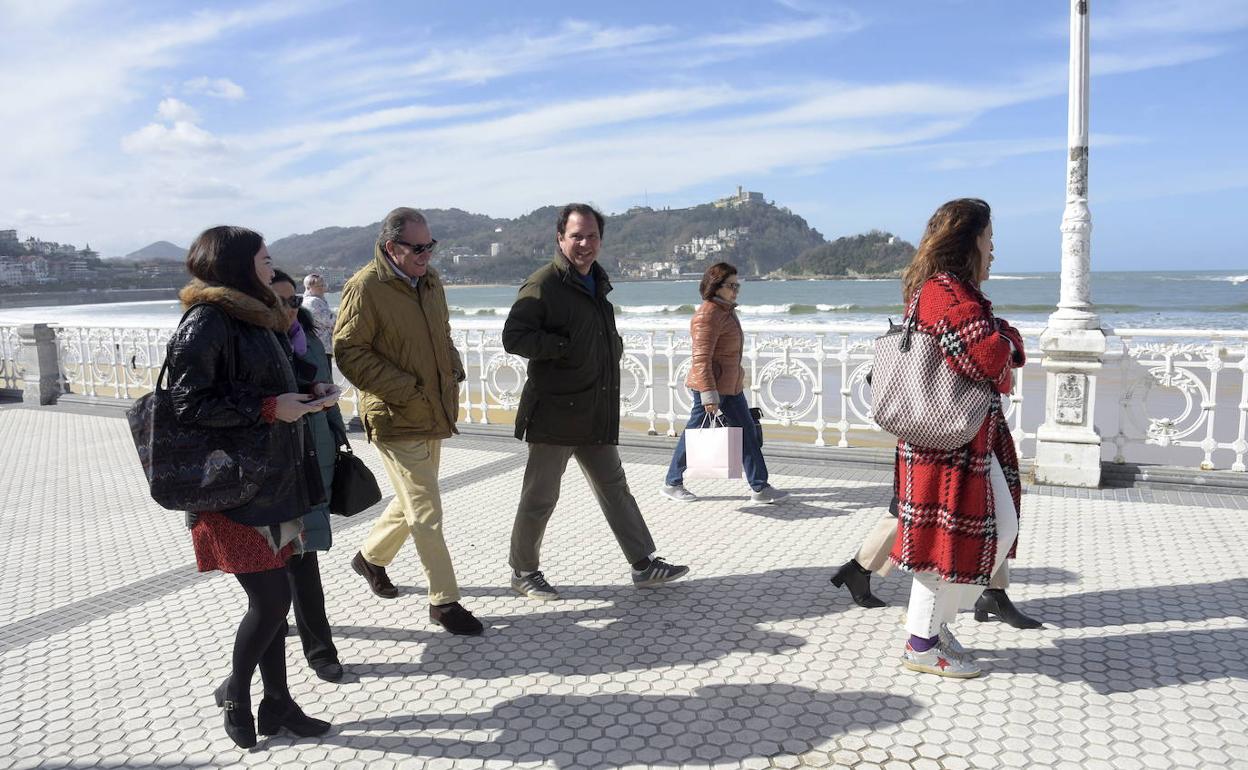 Viandantes caminando por el paseo de La Concha. 