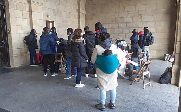 Varios migrantes en el punto de información colocado en los bajos del ayuntamiento de Irun.