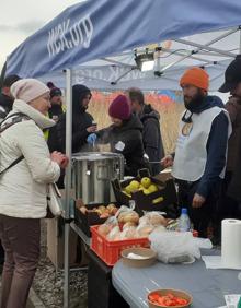 Imagen secundaria 2 - Un autobús llega al campo de refugiados organizado en Przemysl para evacuar a medio centenar de ucranianos. La mayoría son mujeres, niños y niñas. Una mochila es todo su equipaje. Benito Escat y Olivia Fernández, en los extremos, cobijaron en su autocaravana 'maternal' a Elena, Sasha, Sofia y Ania antes de venir a Gipuzkoa. el puesto de comida de la ONG World Central Kitchen del cocinero José Andrés, que en 2020 recibió el Basque Culinary World Prize..
