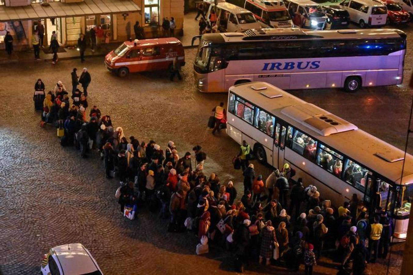 Refugiados de Ucrania hacen cola para subirse a autobuses a otros destinos en Polonia.