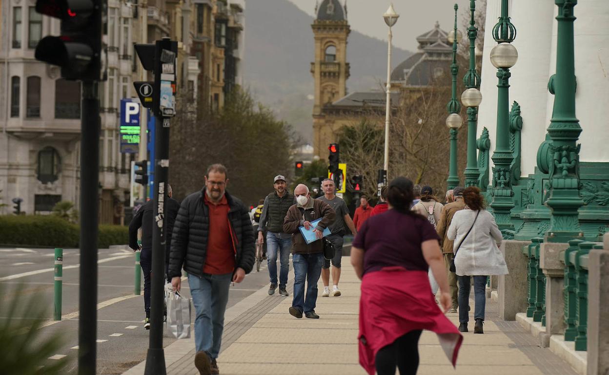 Viandantes paseando por el puente del Kursaal de Donostia. 