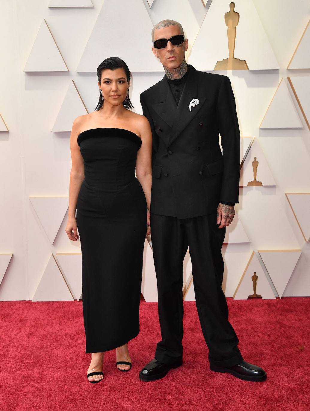 Kourtney Kardashian y Travis Baker han llegado sonrientes y de la mano a la 'red carpet'. Ella, con un palabra de honor midi de Mugler, y él, con un traje de Maison Margiela. En esta ocasión, ambos han optado por la discreción