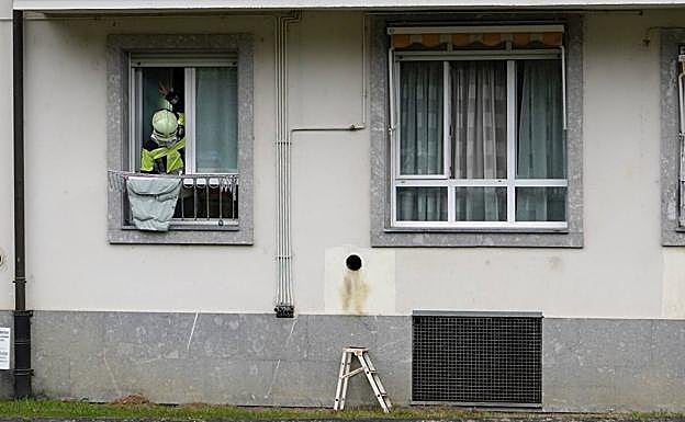 Galería. Un bombero inspecciona las tuberías de gas en la fachada de la vivienda.
