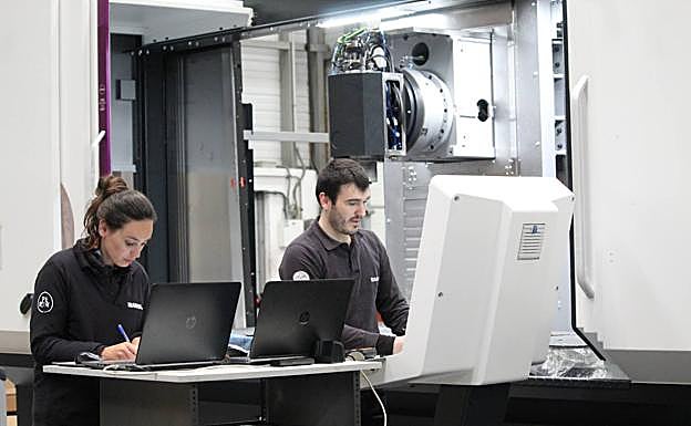 Dos empleados de Ibarmia trabajan sin mascarilla tras el levantamiento de su obligatoriedad en interiores.