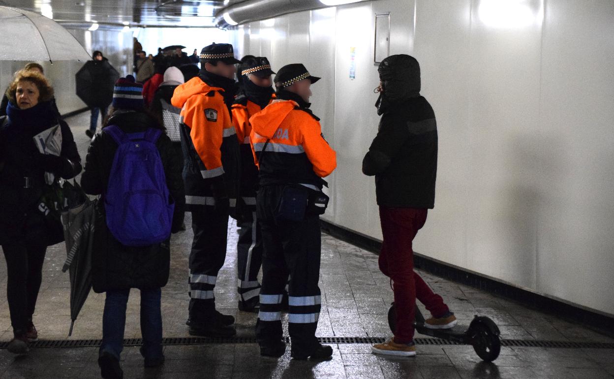 Tres agentes de Movilidad hablan con un usuario de patinete eléctrico en el pasadizo de Egia.