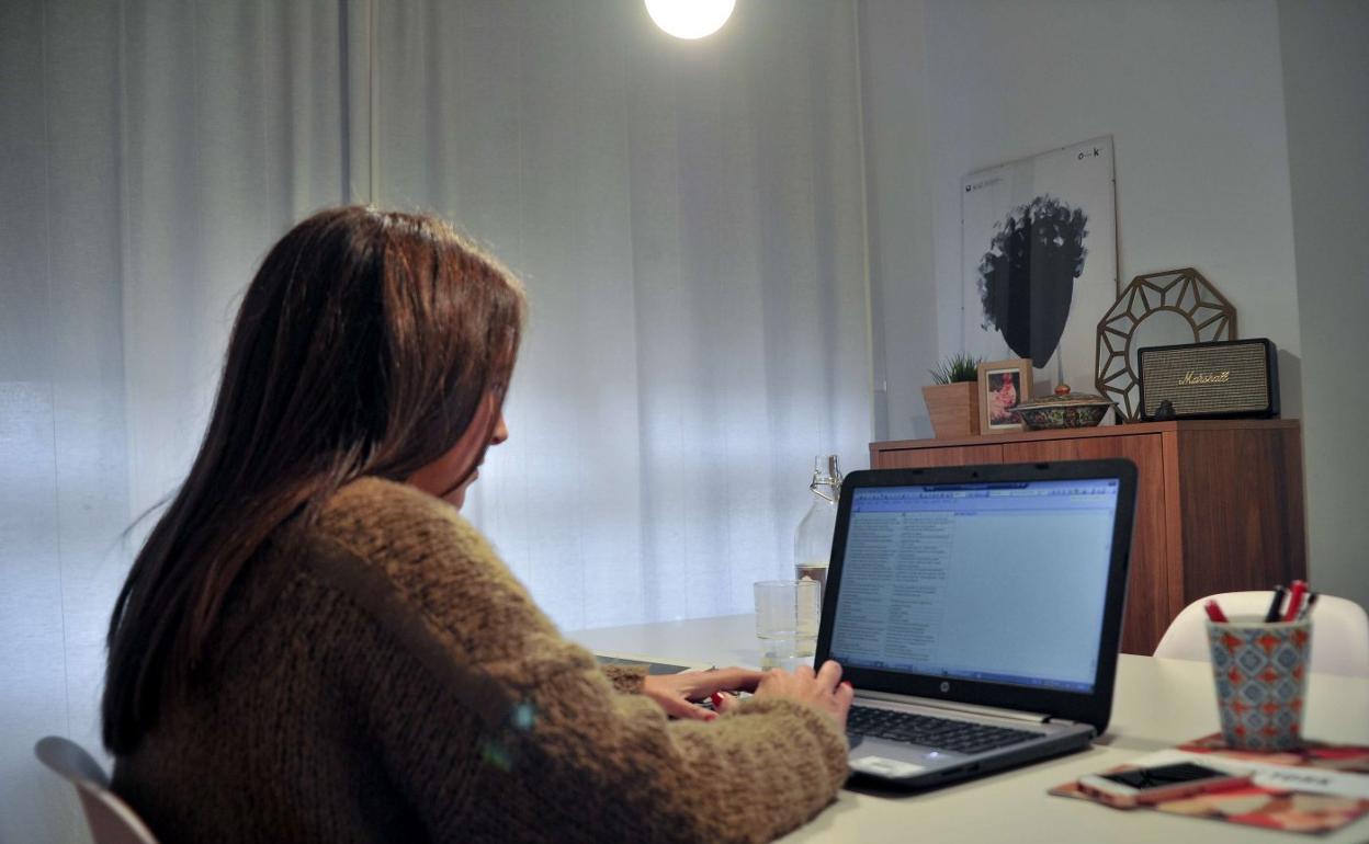 Una joven donostiarra trabaja con un ordenador en el interior de su casa. 