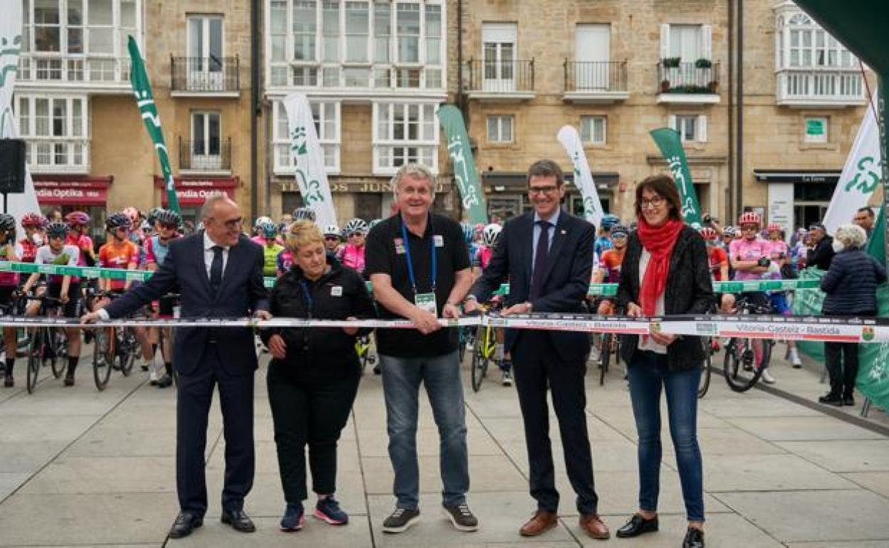 Julián Eraso, en el centro, corta la cinta de la Itzulia esta mañana en Vitoria.