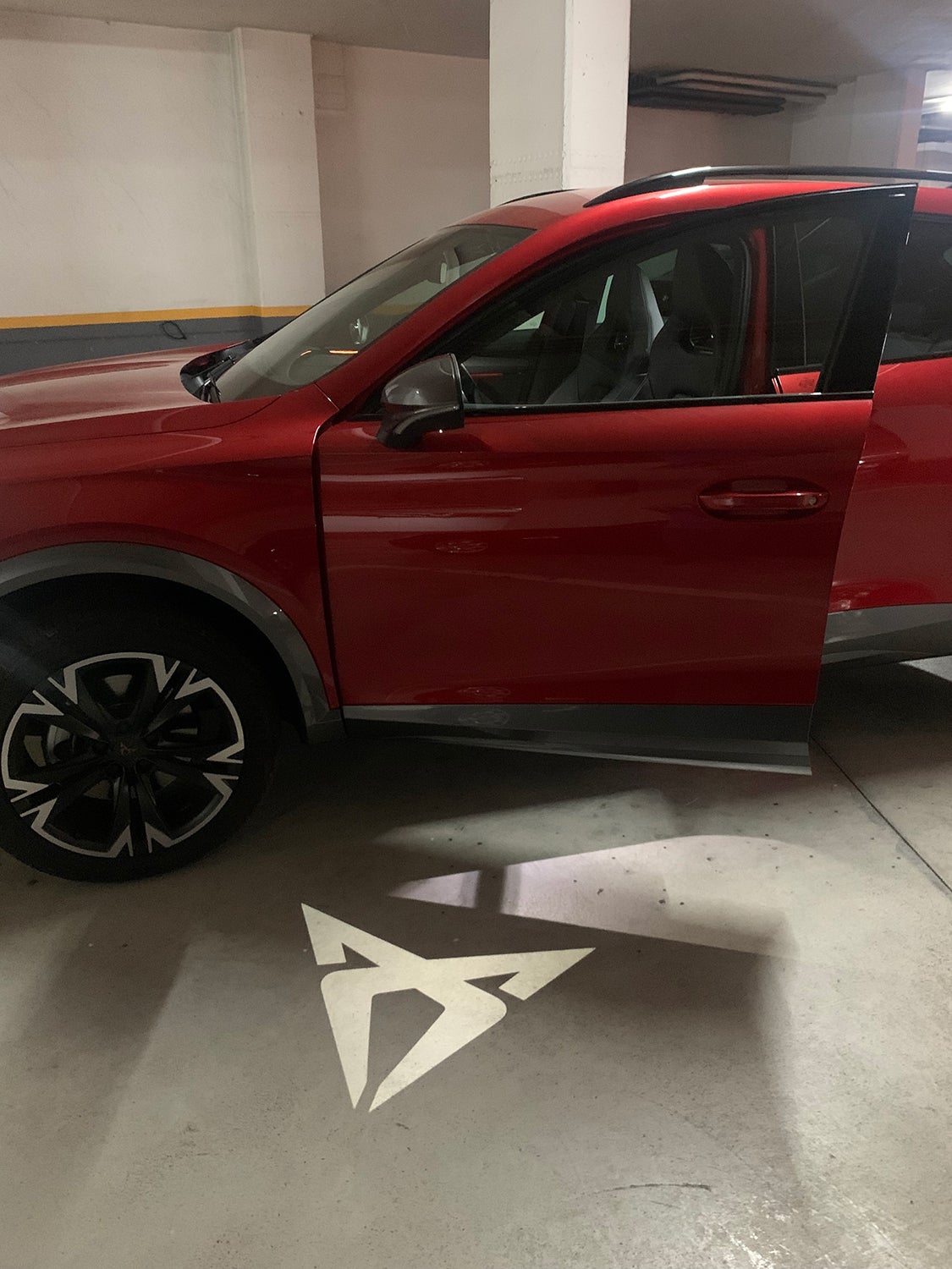Al abrir la puerta en oscuridad (garaje) proyecta una iluminación con el logo de Cupra en el suelo