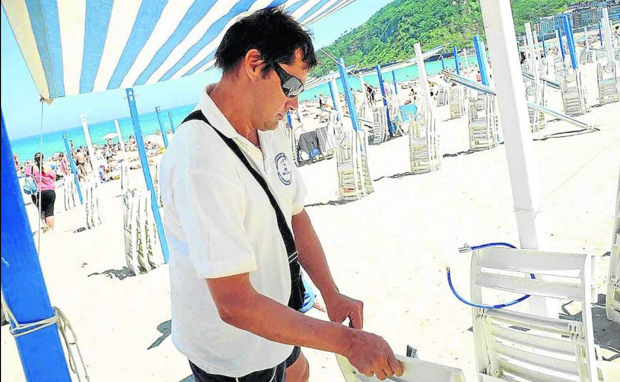 Un toldero prepara un puesto. 