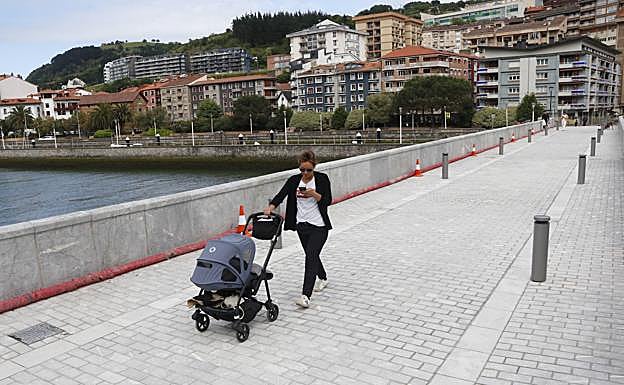 Imagen principal - Varios vecinos cruzan y observan cómo ha quedado el puente, que colapsó en 2018, como se ve en la imagen. 
