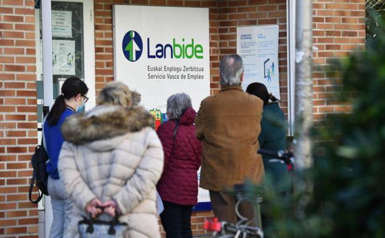 Varias personas hacen cola en el exterior de una oficina de Lanbide. 