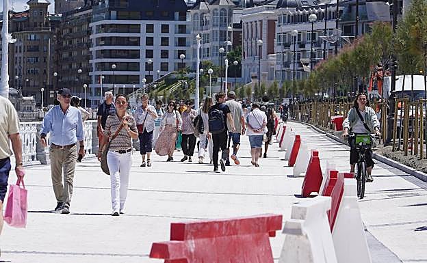 Imagen principal - La mayor anchura es apreciable pese a que los ciclistas transitan provisionalmente por la acera. La calle Zubieta luce nuevo asfaltado y las señales que adelantan el próximo cambio de dirección.