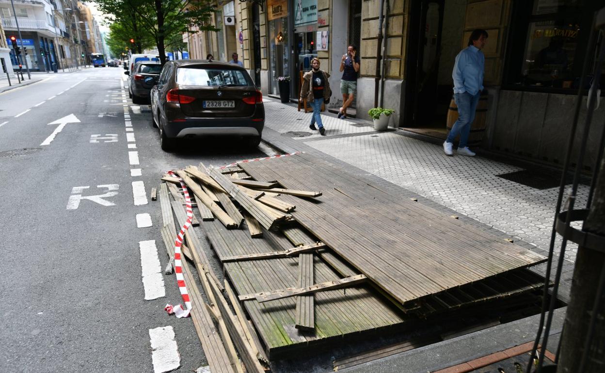 Desmontaje de una terraza Covid sobre una zona de aparcamiento, este viernes en el centro de San Sebastián. Estas instalaciones quedan prohibidas este sábado. 