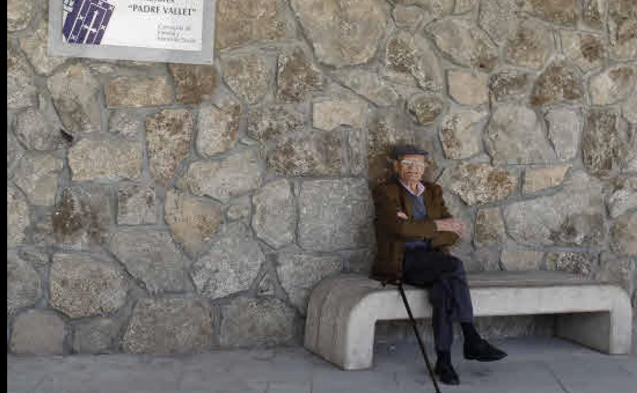 Un pensionista descansa en un banco. 