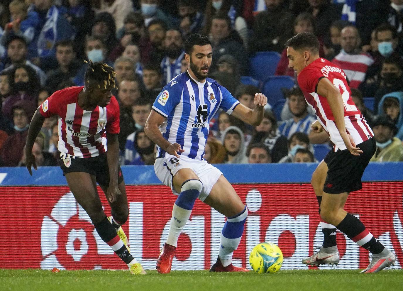 Mikel Merino pugna con Nico Williams y Petxarroman en el derbi disputado en Anoeta. 