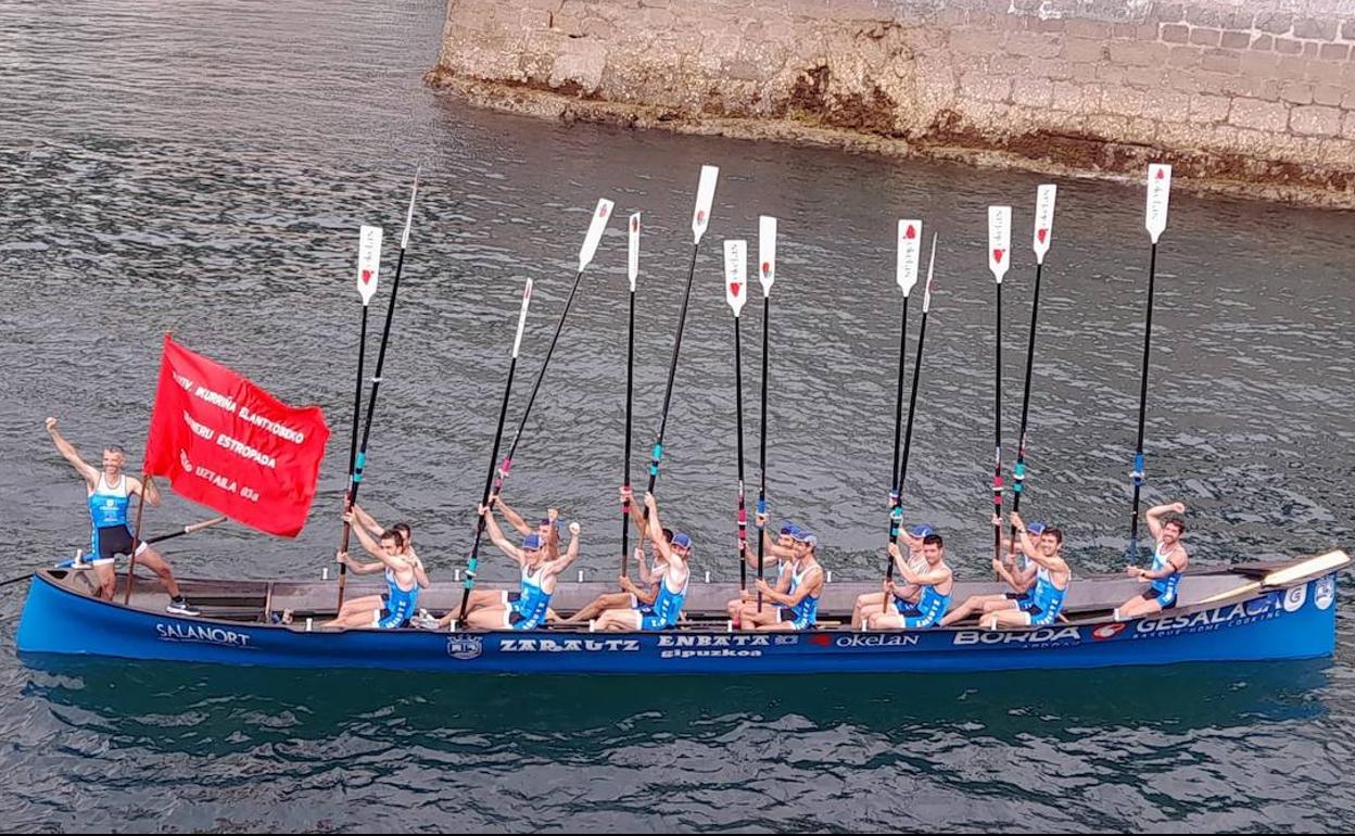 Los remeros de Zarautz Gesalaga Okelan levantan los remos para celebrar la victoria en Elantxobe. 