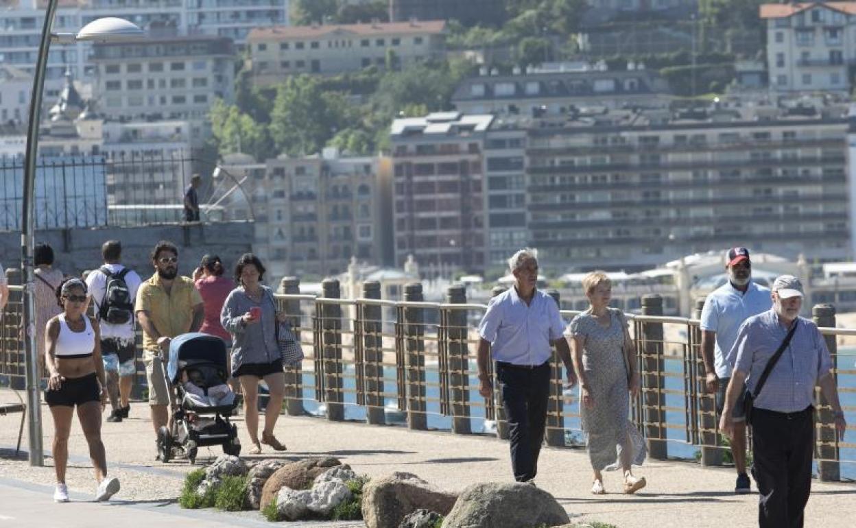 Donostiarras y turistas paseando por el Paseo Nuevo este domingo. 