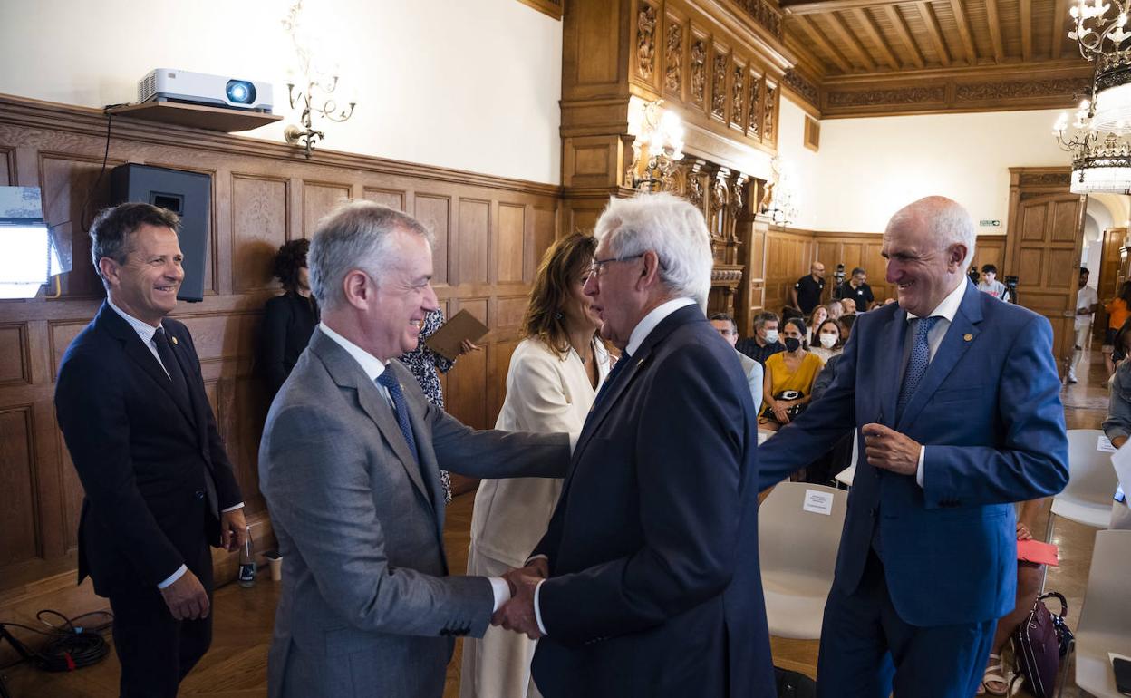 Urkullu saluda a Pedro Miguel Etxenike, en presencia de Jokin Bildarratz, ayer en los Cursos de Verano en Donostia, antes de ir a Vitoria.