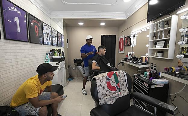 Imagen principal - Bilal es especialista en hacer el 'fade' o degradado, el corte de moda entre los jóvenes y deportistas. 