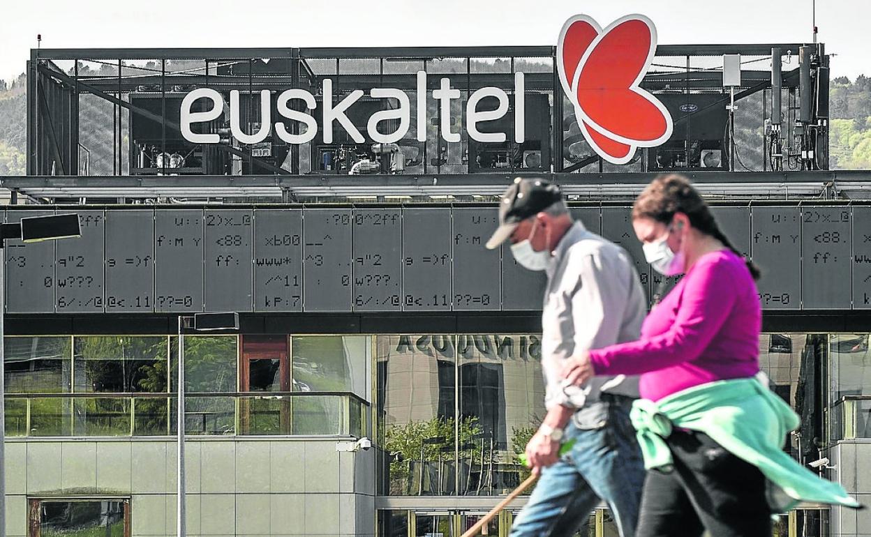 Dos personas pasean frente a la sede de Euskaltel, en Zamudio. 