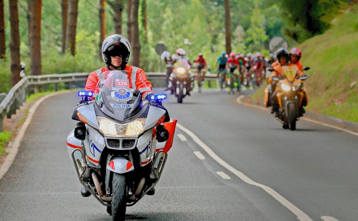Un ertzaina abre el paso del pelotón en una prueba ciclista. 