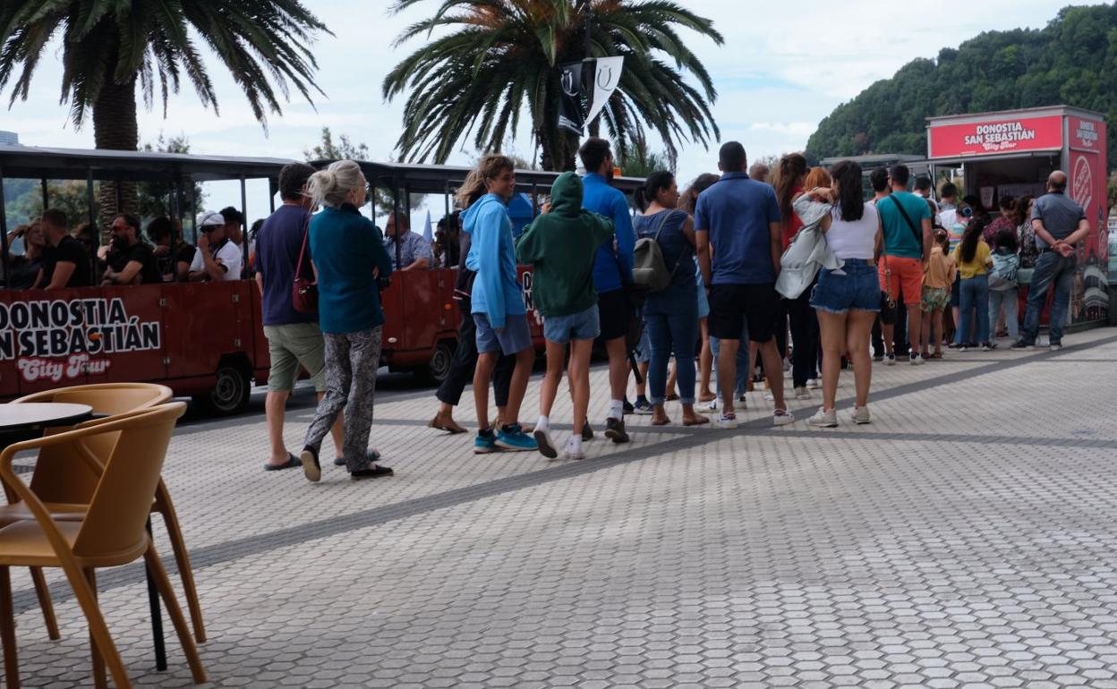 Colas de turistas para subirse al tren Txu Txu, ayer en San Sebastián. 