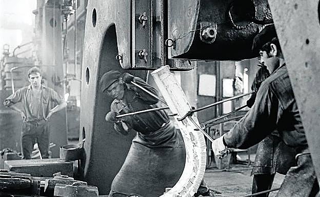 Abel Araguzo, en el centro manipula una escultura al rojo vivo en la ferrería de Legazpi. 