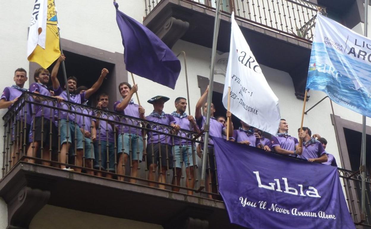 Los remeros de Sanpedrotarra festejando el final de temporada y sus banderas en el balcón de la Tenencia de Alcaldía. 