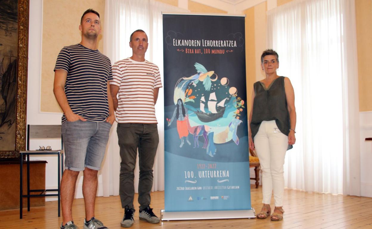 Beñat Aristi, Haritz Alberdi y Ane Loidi, con el cartel anunciador del desembarco. 