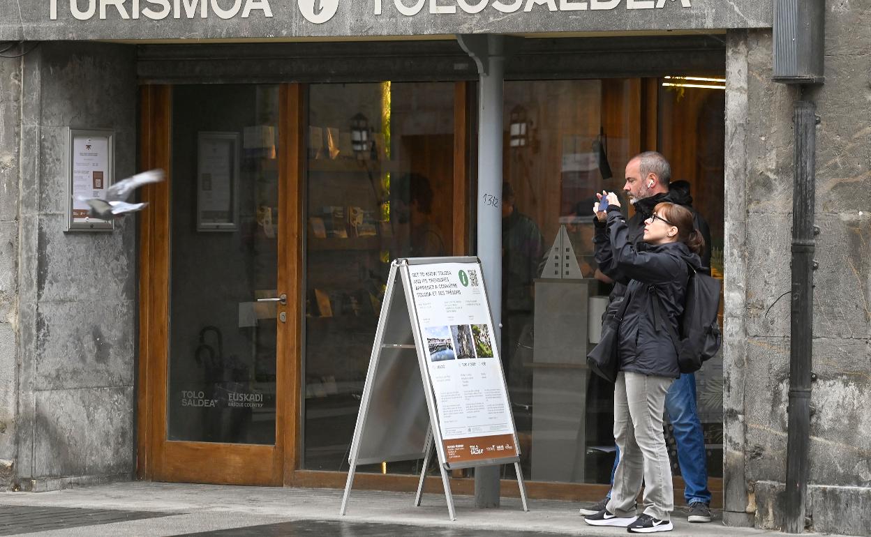 Imagen de dos turistas en el exterior de la nueva oficina de turismo de Tolosaldea. 