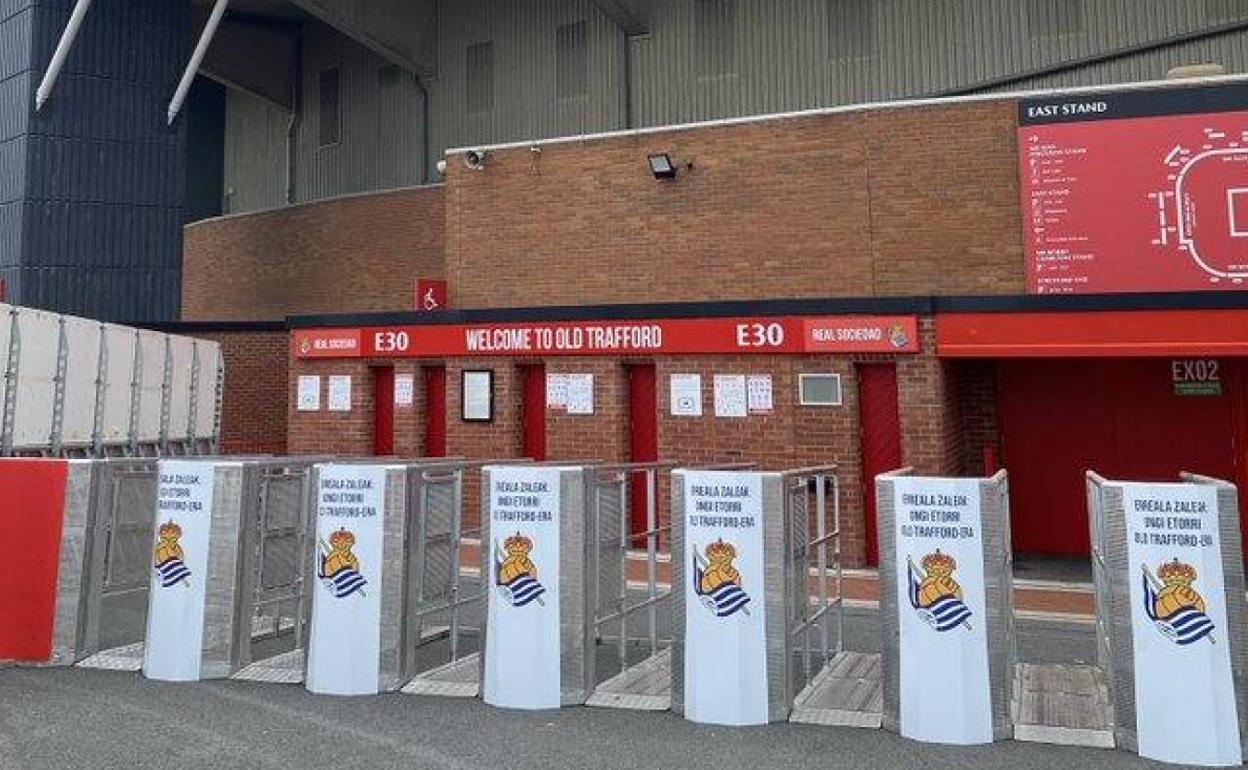 El escudo y la bienvenida a la Real Sociedad en los acceso a Old Trafford