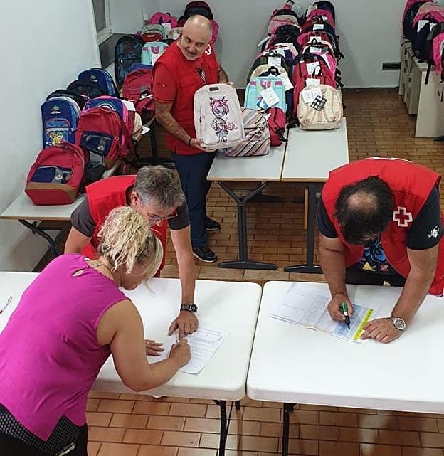 Voluntarios de Cruz Roja preparando el material escolar. 