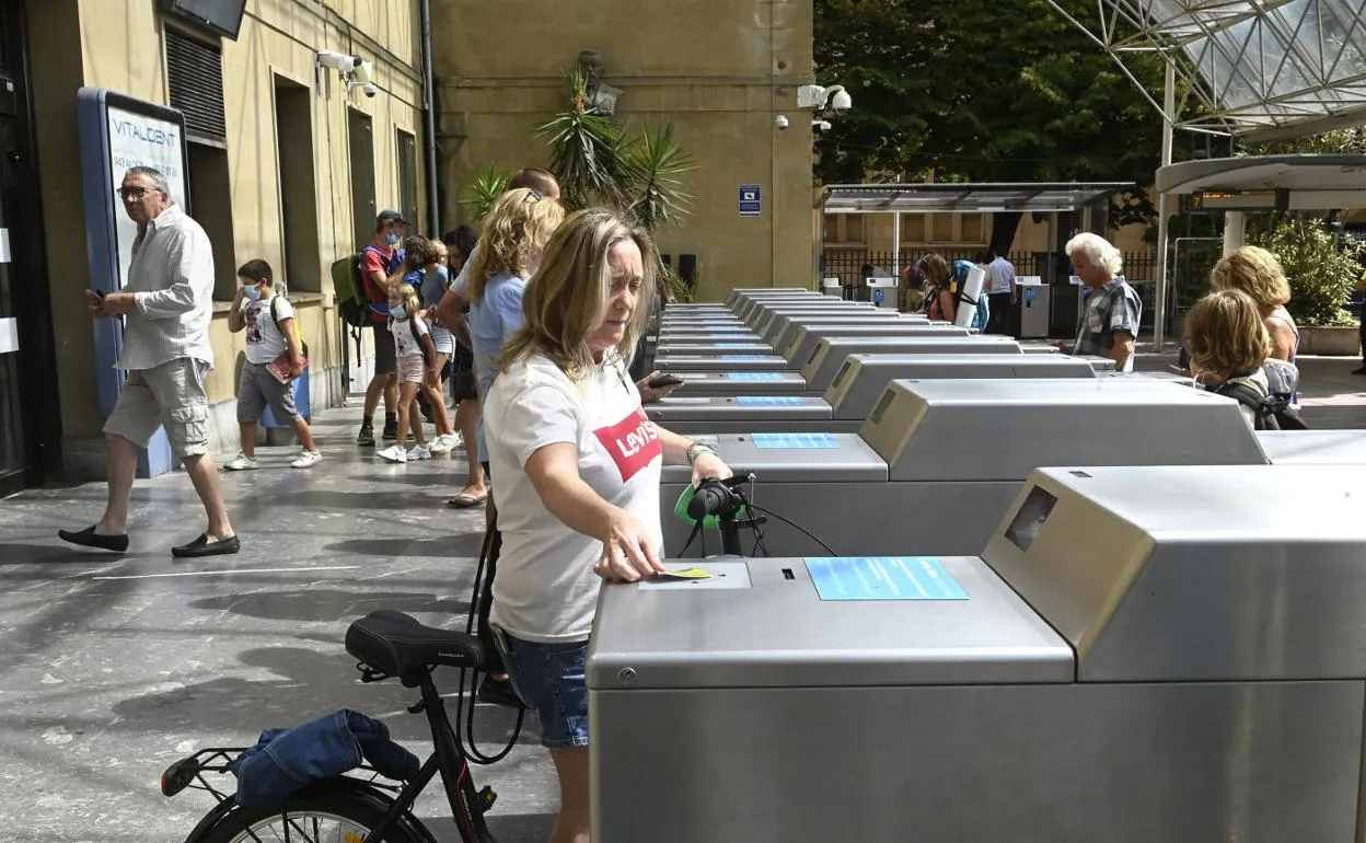 Usuarios de Euskotren pasan la Mugi por los lectores para entrar y salir de la estación de Amara en San Sebastián. 