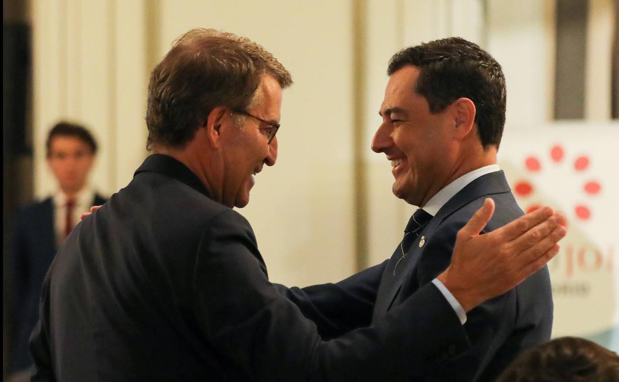 El presidente andaluz, Juanma Moreno, se saluda con el líder del PP, Alberto Núñez Feijóo, este lunes.
