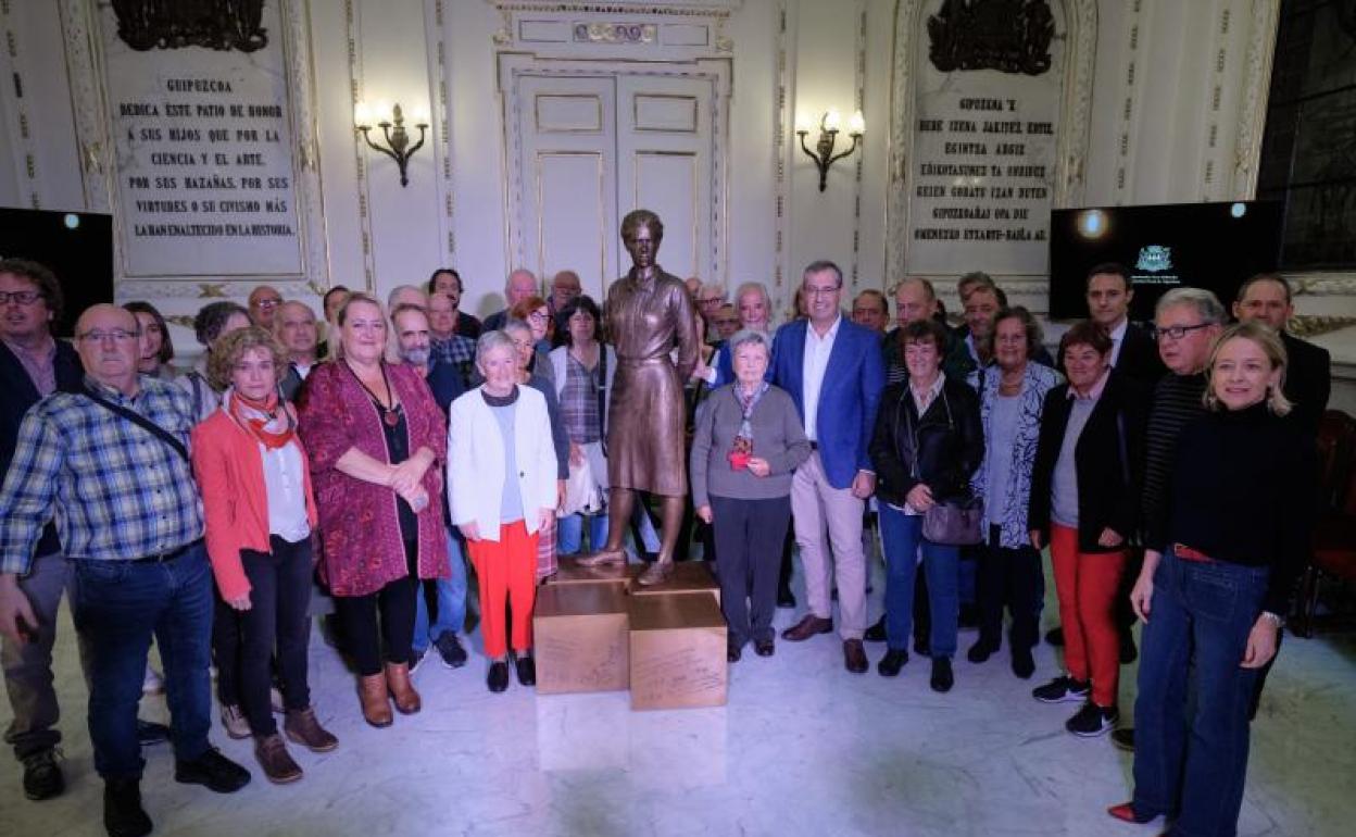 Kontxita Beitia y Mari Karmen Mitxelena, junto a la escultura de Zipitria, acompañadas por el diputado general, Markel Olano, y los invitados al acto en el patio de honor de la Diputación. 