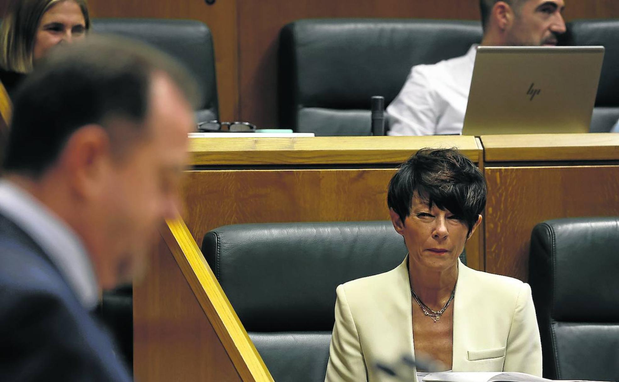 Maddalen Iriarte, de EH Bildu, escucha ayer al popular Carlos Iturgaiz en el Parlamento Vasco.