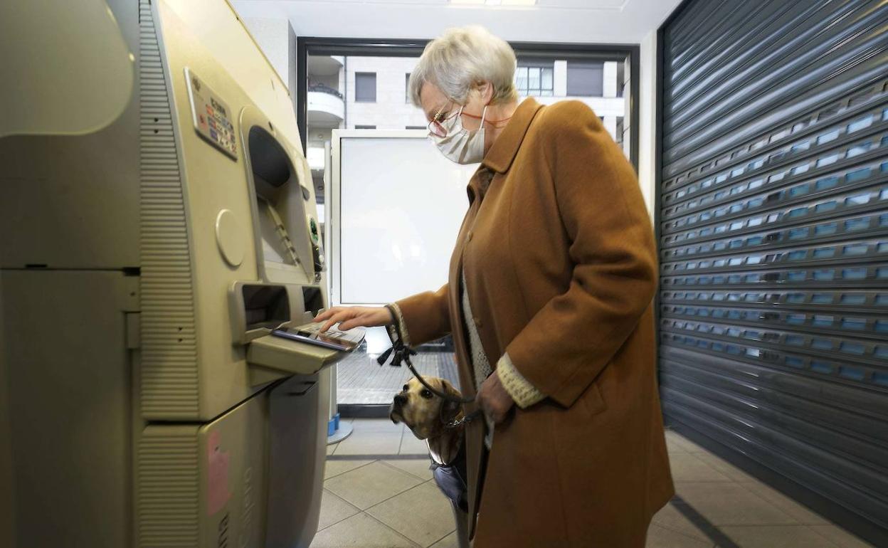Una usuaria utiliza un cajero de una sucursal bancaria.