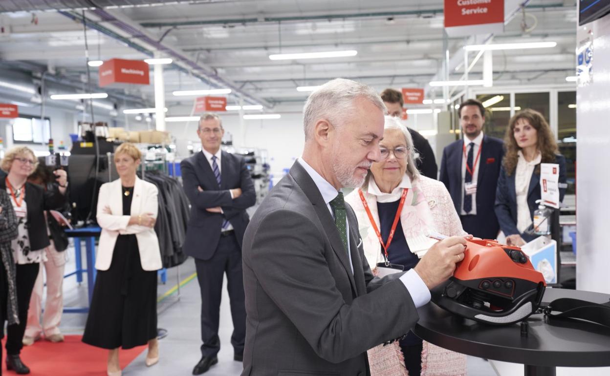 El lehendakari firma una máquina de la empresa de sistemas de radiocontrol Danfoss junto a Tapia y Olano.