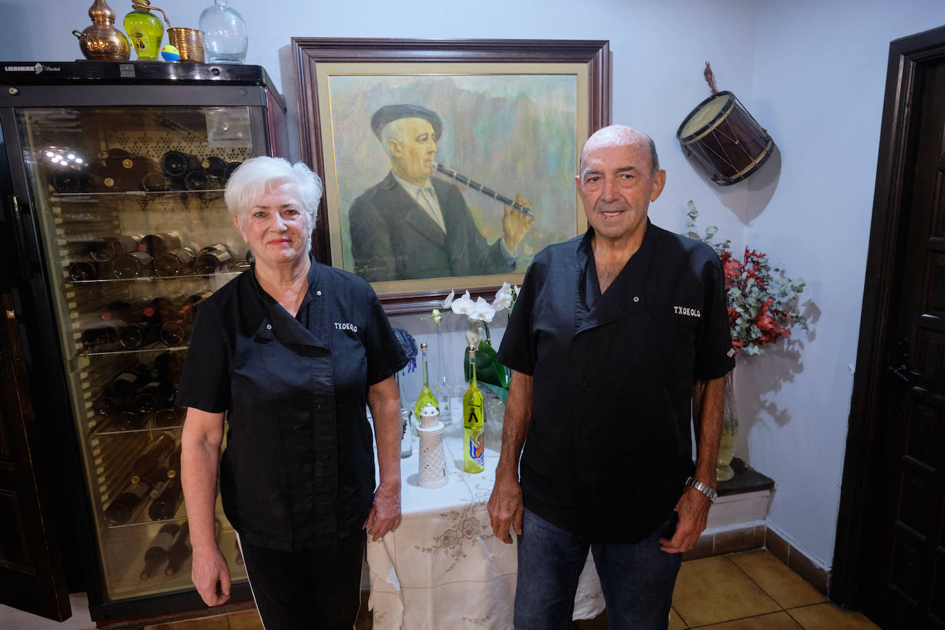 Mari Carmen Aginagalde e Iñaki Illarramendi posan este martes para la foto de despedida con el cuadro del txistulari 'Txokolo' y su tamboril al fondo. 