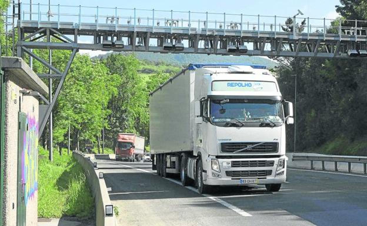 Un camión cruza uno de los pórticos instalados en la N-I para el peaje de camiones, en Andoain.