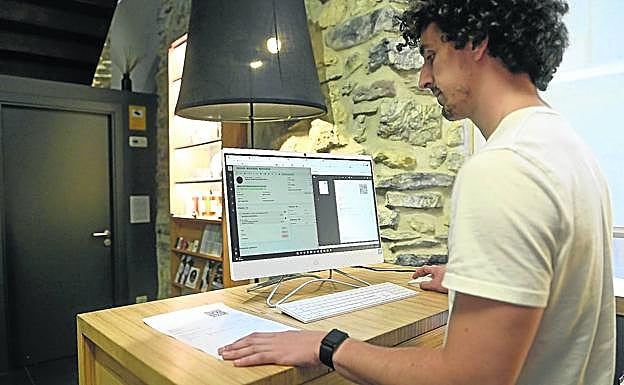 Beñat Martín, en la recepción del hotel Bide Bide de Tolosa, emite una factura en su ordenador.