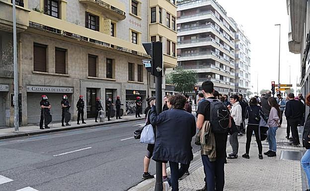 Agentes de la Ertzaintza impiden a las personas que se han congregado acercarse al portal.
