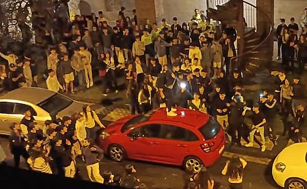 Un joven subido a un coche en Aiete, rodeado de una multitud en Halloween.