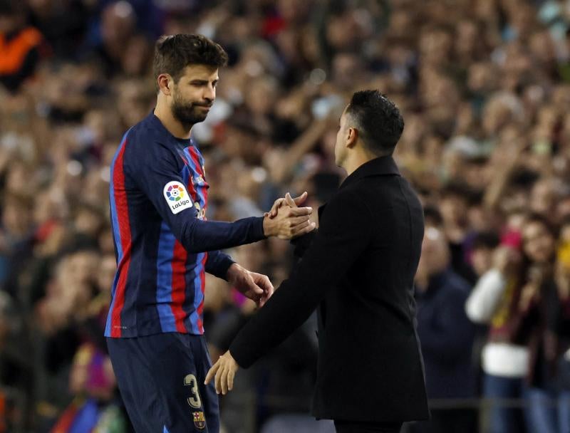 Piqué saluda a Xavi durante su sustitución.