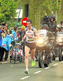 Imagen secundaria 2 - Arriba, Pedro Nimo en la Behobia de 2014, con la hermana de Arantza, fallecida en 2013. Abajo a la izquierda, cartulina de apoyo de unas jóvenes, trofeo, txapela y ramo de 2013. A la derecha, Nimo sube destacado el alto de Miracruz en 2013, cuando ganó.