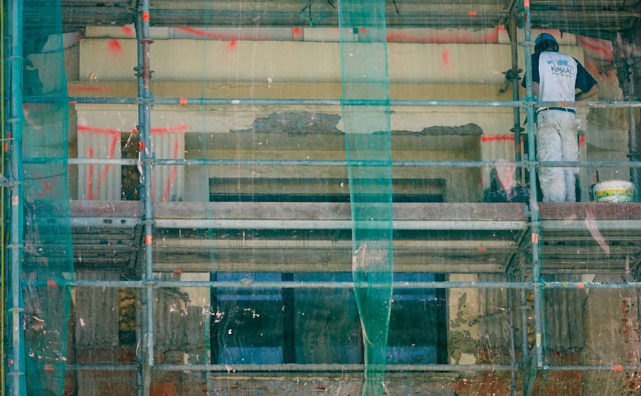 Un obrero trabaja en la rehabilitación de la fachada de un edificio antiguo del Centro.