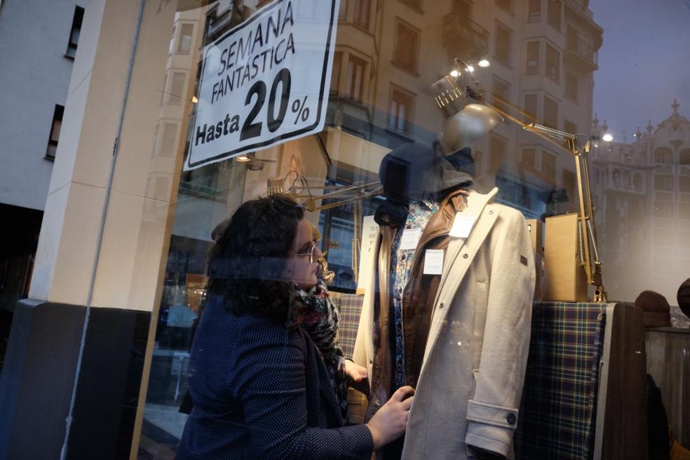 Semana Fantástica. Irma Aldabaldetreku prepara un maniquí en el escaparate con el cartel de descuentos