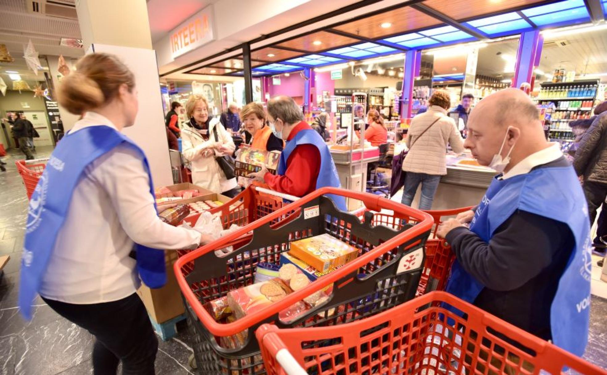 Dos de los voluntarios trabajando este viernes en la Gran Recogida en el Super Amara del Centro donostiarra.