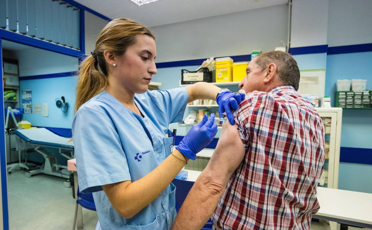 Una enfermera inocula la vacuna contra la gripe a un paciente. 