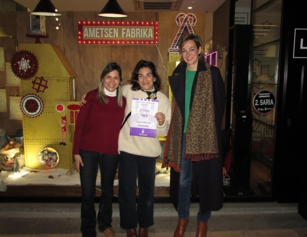 Ricardo Vázquez y Javier Inda ante el escaparate de la perfumería Altuna, ganador del certamen. 